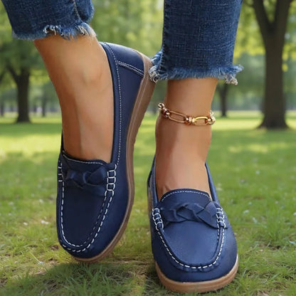 Dunkelblaue Loafer mit weißer Ziernaht und geflochtener Zierbrücke, getragen zu Fransenjeans auf einer Wiese im Park. 6