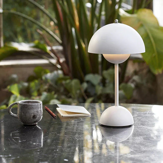 Weiße Tischlampe aus Metall, modern, auf Marmortisch mit Tasse und Notizbuch, Innenraum.