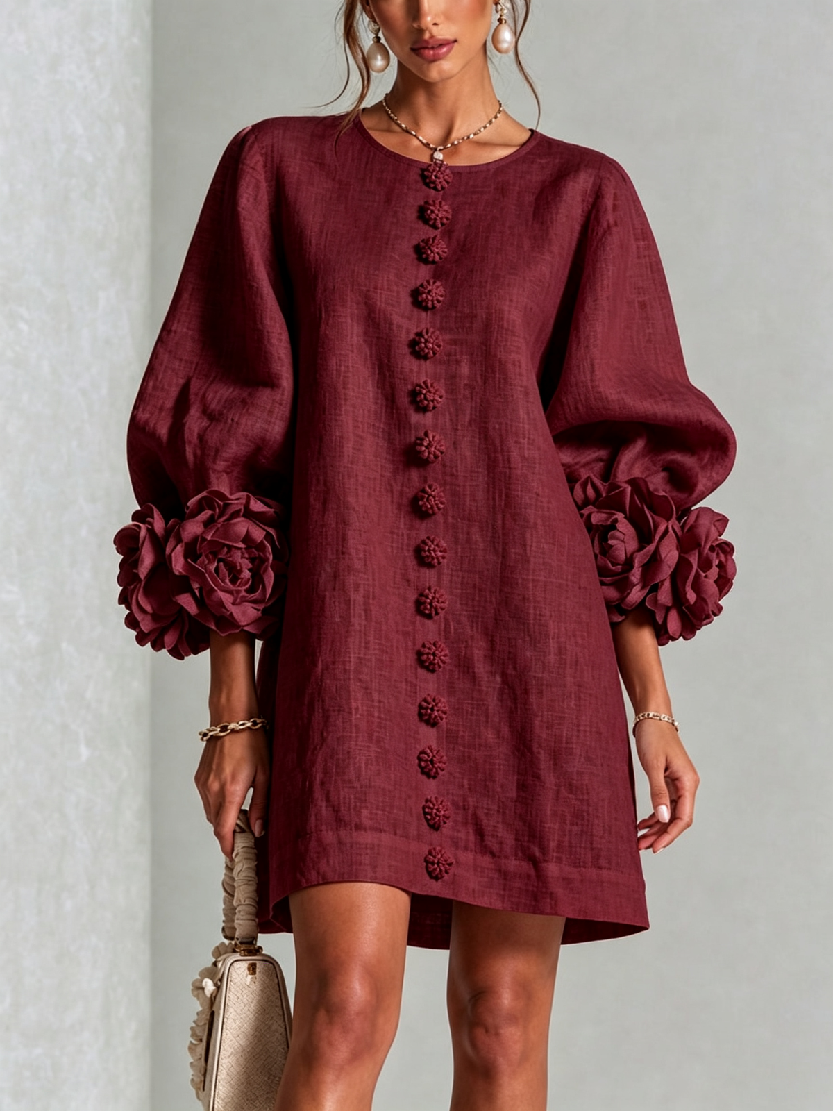 Weinrotes Kleid frontal als Nahaufnahme mit Reihe von Blütenknöpfen, Puffärmeln und großen Rosenmanschetten im Studio. 35