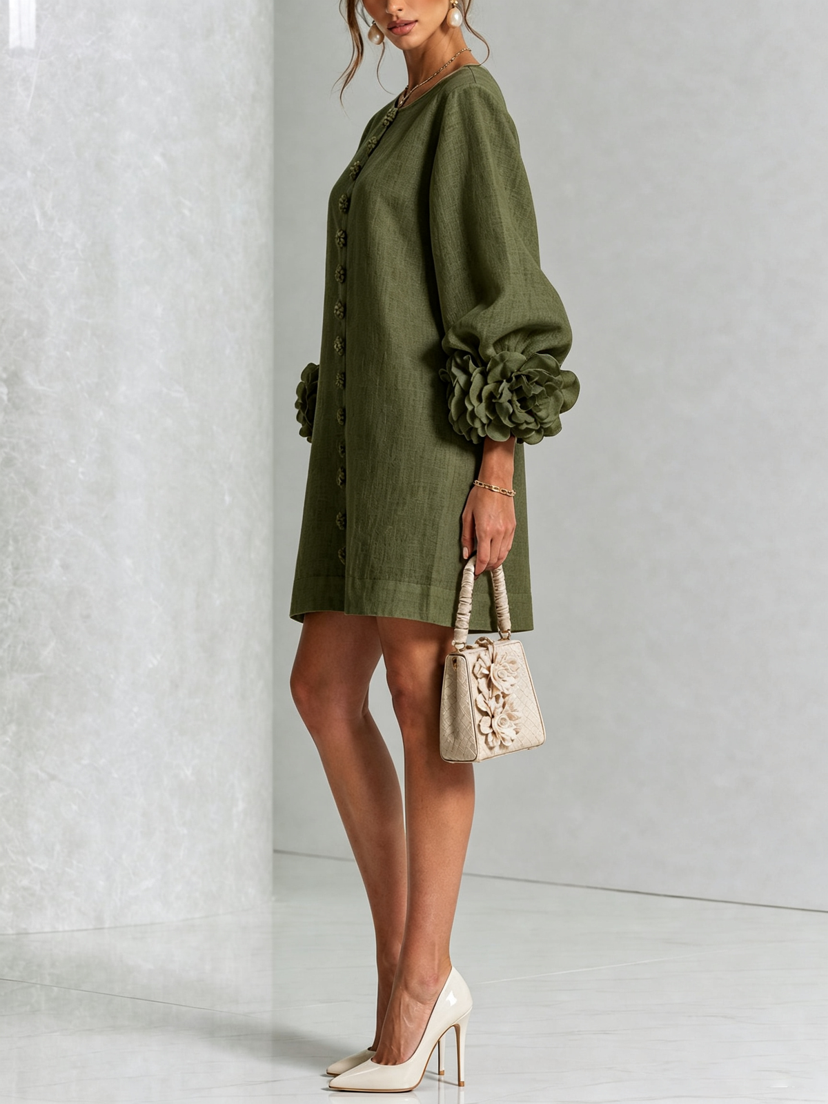 Olivgrünes Minikleid in der Seitenansicht, Model mit Handtasche und hellen Pumps, Rosenmanschette am Ärmel sichtbar. 8
