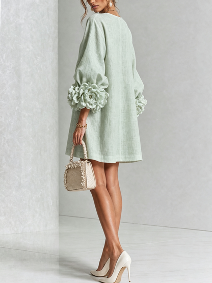 Mintgrünes Kleid in der Rückansicht mit schlichtem Rücken und großer Rosenmanschette am Ärmel, dazu kleine Handtasche und Pumps. 33