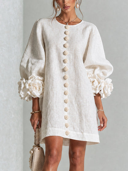 Weißes Minikleid mit Puffärmeln, Rosenmanschetten und Blumenknopfleiste, getragen von einem Model in der Frontansicht, mit beiger Handtasche. 1