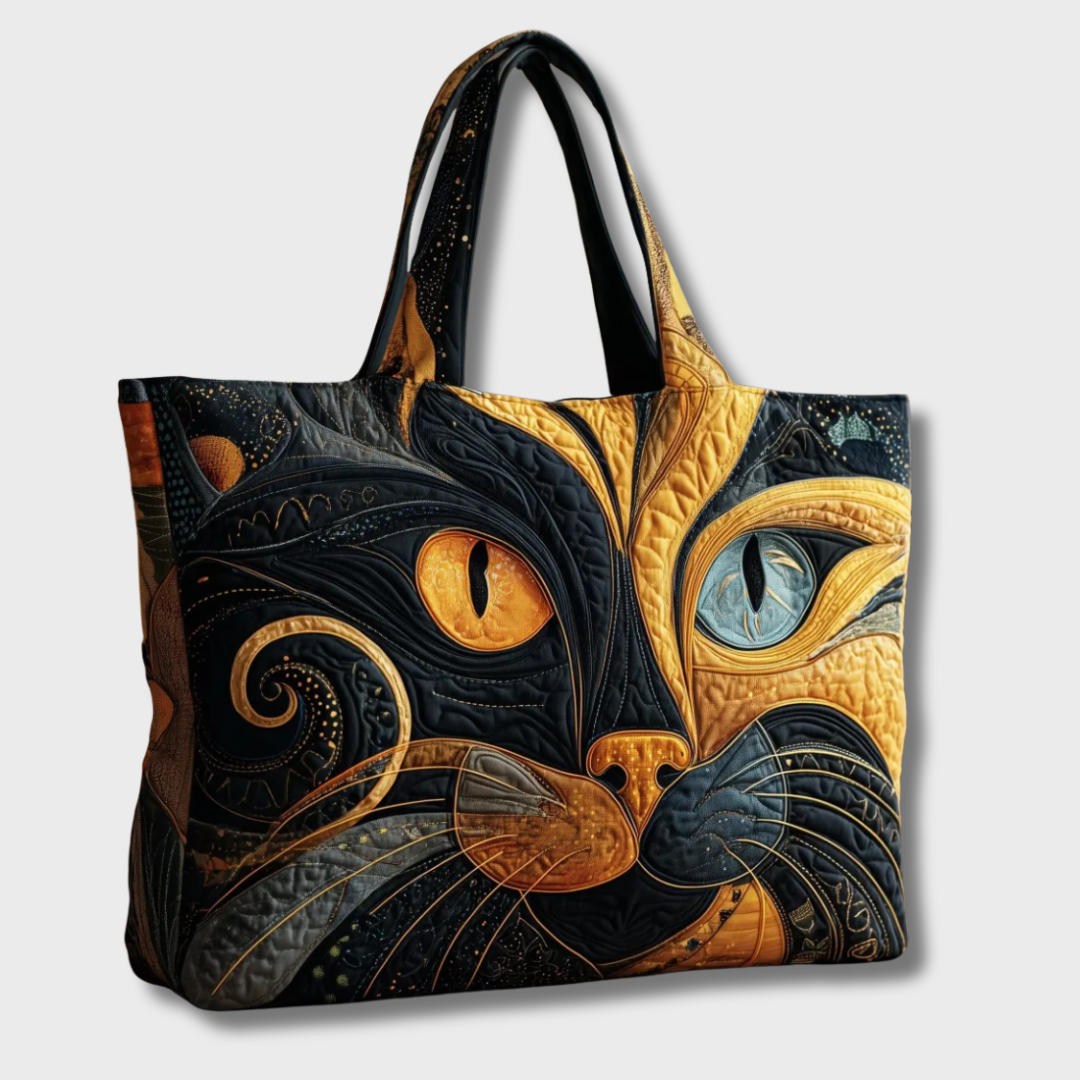 Seitliche Ansicht der gesteppten Tasche mit Katzenmotiv und zwei schwarzen Henkeln vor hellem Hintergrund 2