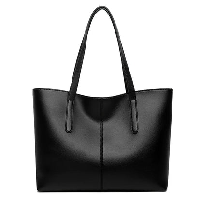 Schwarze Tote-Tasche in Frontansicht vor weißem Hintergrund, mit Mittelnaht und zwei langen Riemen 1