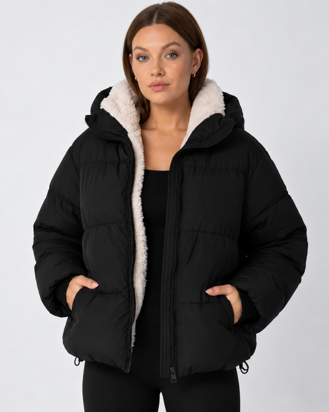 Schwarze Steppjacke offen getragen, cremefarbenes Teddyfutter am Kragen, Hände in den Taschen 11