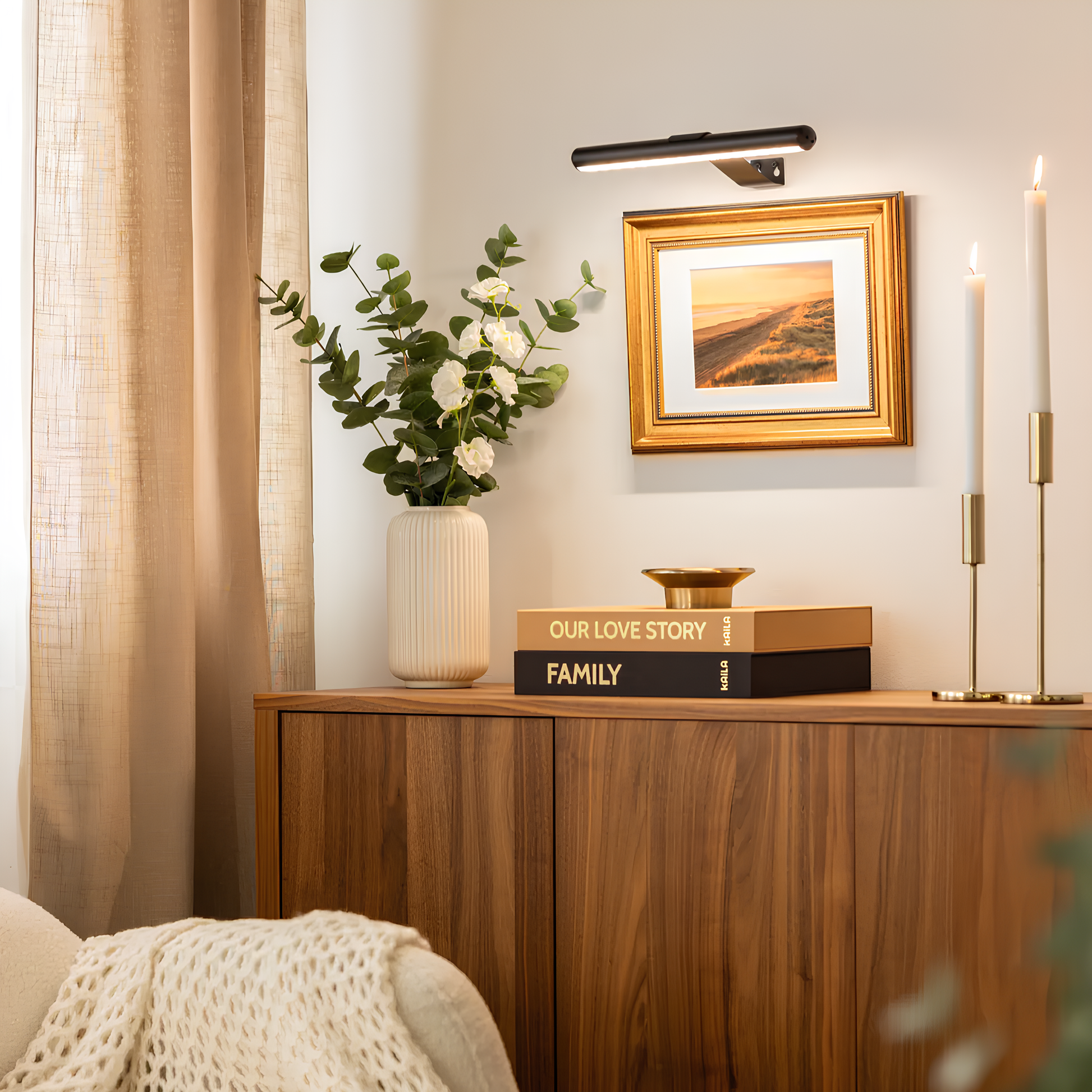 Holzkommode mit Vase, Bücher, Kerzenhalter und Bild an der Wand, gemütliche Wohnzimmerdekoration.