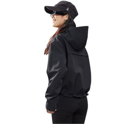 Seitliche Rückansicht der schwarzen Jacke mit Kapuze und gerafftem Saum, Trägerin lacht mit Kappe und Sonnenbrille 18