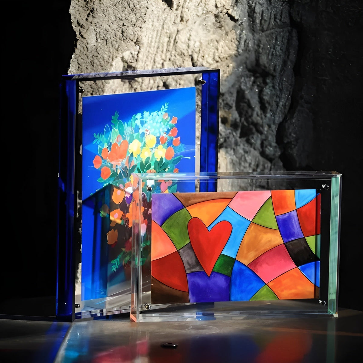 Zwei Acrylrahmen nebeneinander: ein blauer im Hochformat mit Blumenmotiv und ein klarer im Querformat mit buntem Herzmuster. 5