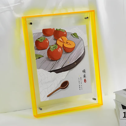 Gelber Acrylrahmen mit Illustration von Kakis auf einem Teller samt Holzlöffel, vor hellem Hintergrund. 12