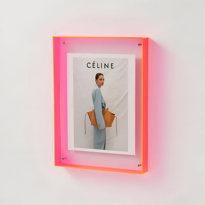Wandmontierter Acrylrahmen in leuchtendem Neonpink mit gerahmtem Modeporträt einer Frau mit brauner Tasche. 18