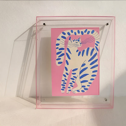 Acrylrahmen mit rosa Kante lehnt an einer Wand und zeigt eine Katzenillustration in Rosa mit blauen Streifen. 9