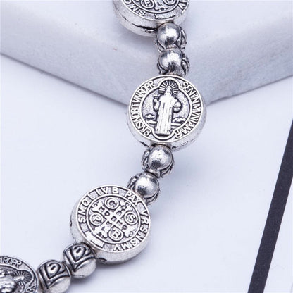 Silbernes Armband mit Benediktus-Medaillen, religiöser Schmuck, detailreich graviert.