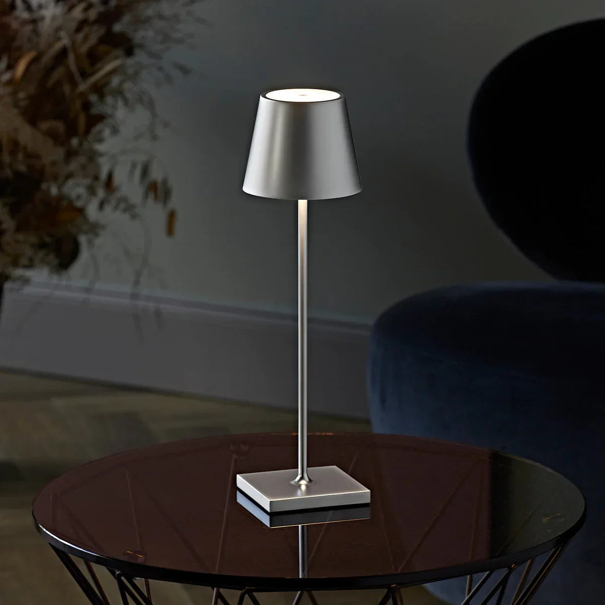 Moderne silberne Tischlampe auf Glastisch, minimalistisches Design, Wohnzimmerbeleuchtung.