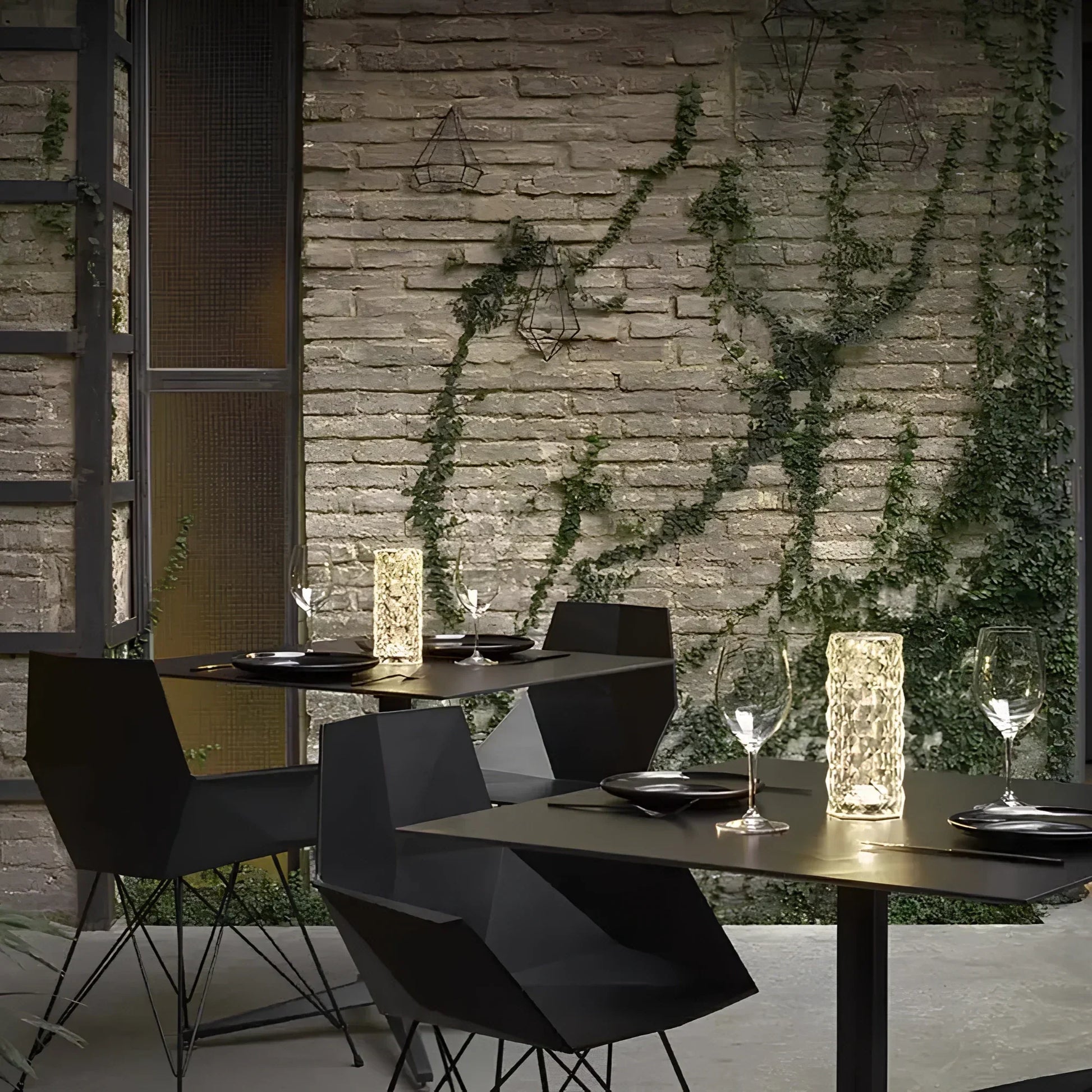 Moderne Terrasse mit schwarzen Stühlen, Holztischen und dekorativen LED-Kerzenleuchten.