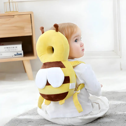 Kleinkind mit gelbem Bienen-Rückenschutzkissen, Sicherheitskissen für Babys, auf Teppich.