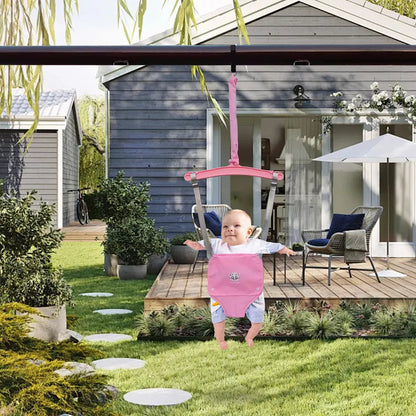 Baby in rosa Türhopser im Garten vor modernem Haus, Holzterrasse, Gartenmöbel, Sonnenschirm.