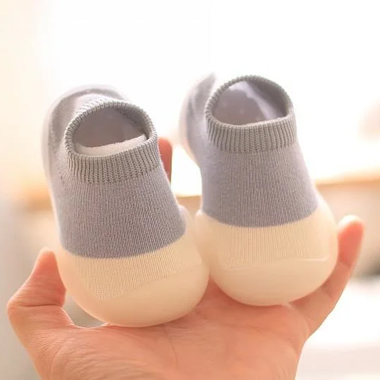 Graue Babyschuhe mit rutschfester Sohle, weiches Material, ideal für Kleinkinder.