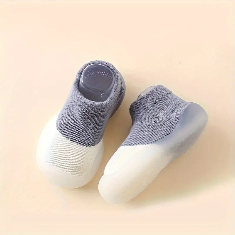 Graue Babyschuhe mit rutschfester Sohle, weiches Material, ideal für Kleinkinder.
