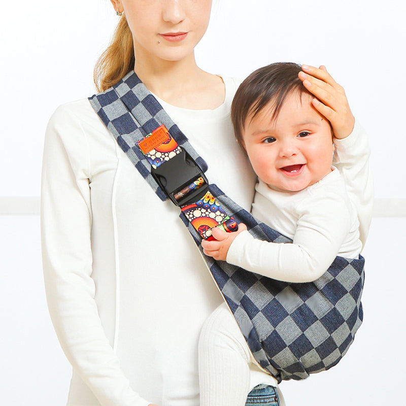 Frau mit kariertem Babytragesitz, blau-weiß, ergonomisch, bequem, für Kleinkinder.