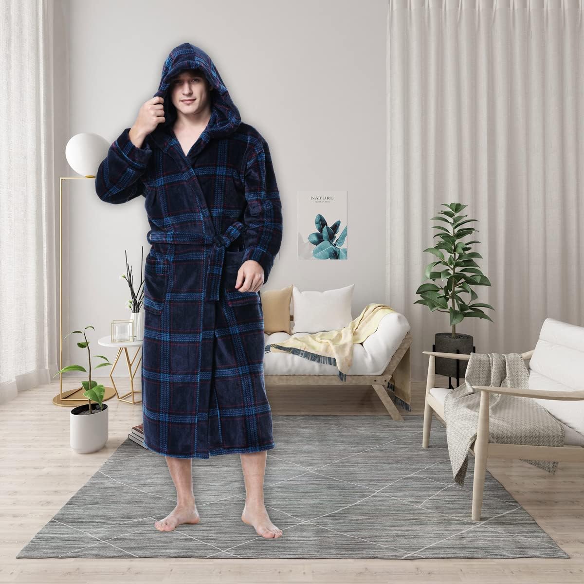 Mann im blauen karierten Bademantel mit Kapuze im modernen Wohnzimmer, gemütliche Atmosphäre.