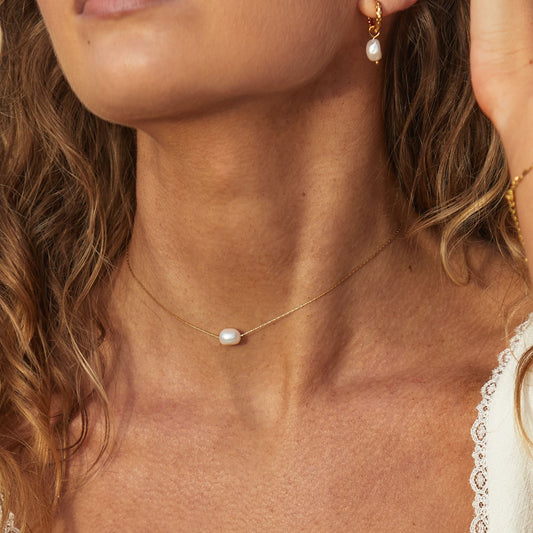 Frau mit Barockperlen-Choker, goldene Kette, eleganter Schmuck, Nahaufnahme.