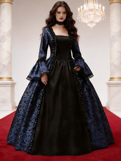 Model trägt das blau-schwarze Kleid mit Blumenmuster und Spitzenärmeln in einem Marmorsaal mit Kronleuchter auf rotem Teppich. 2