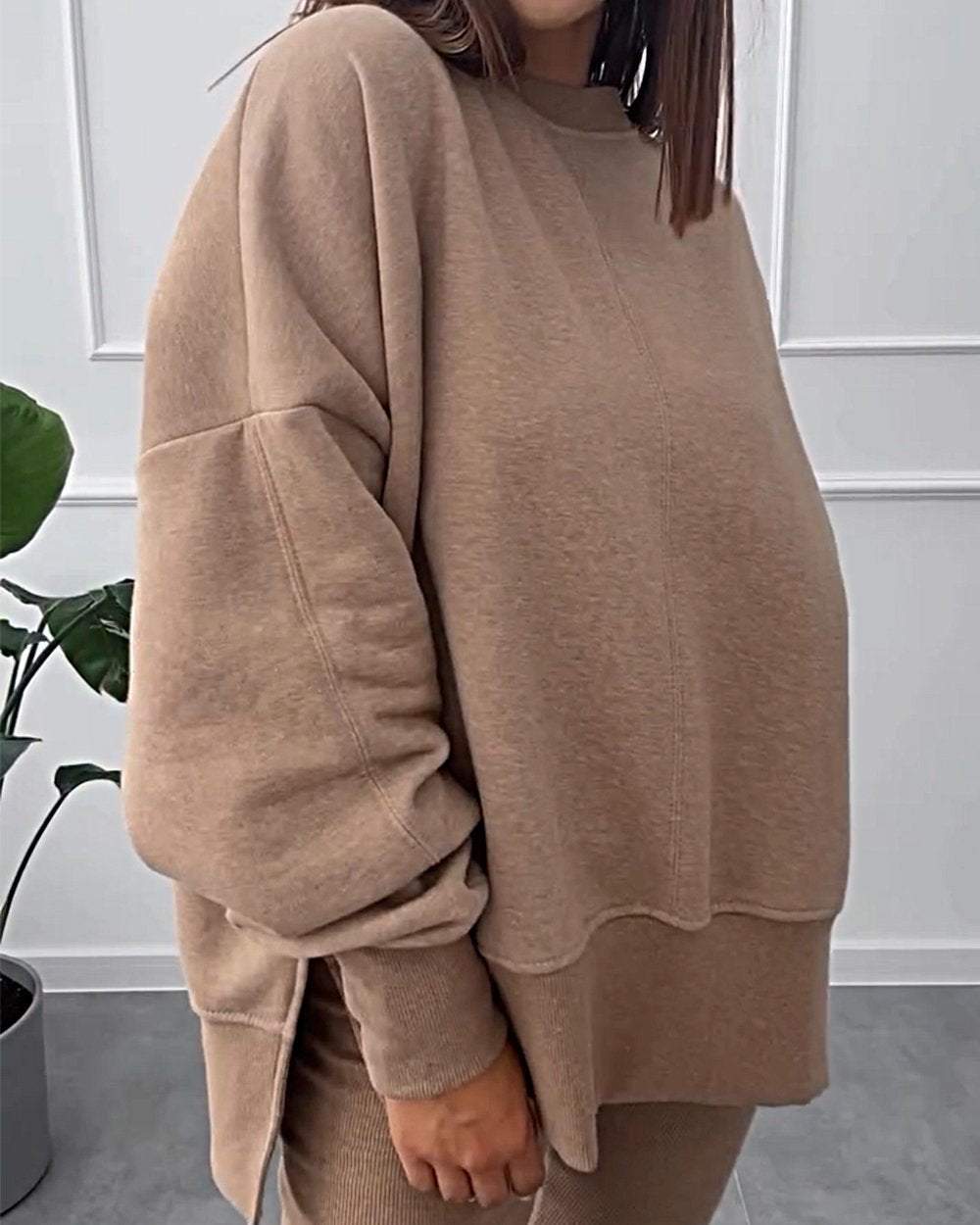 Frau in beigem Oversize-Sweatshirt, gemütlich, modisch, Herbstmode, Innenraum.