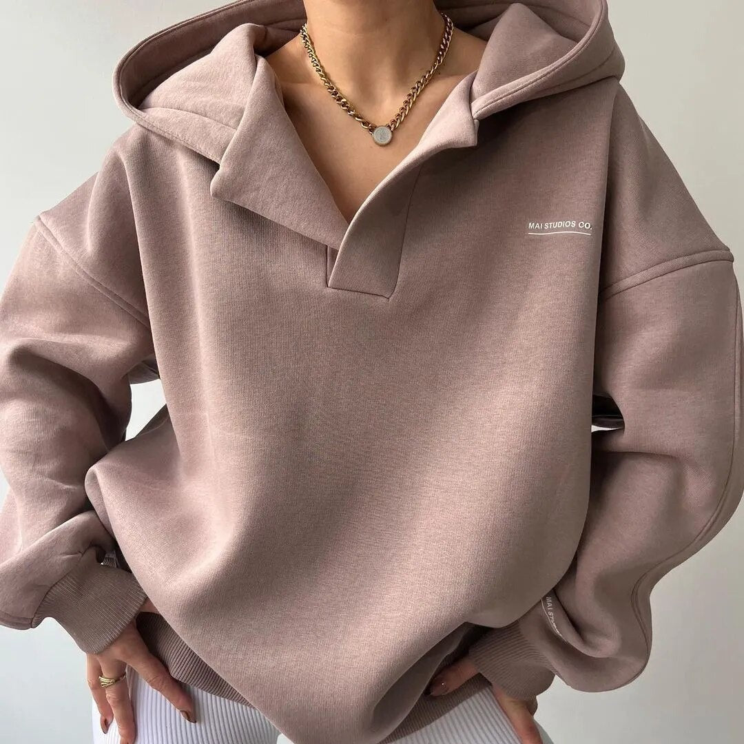 Frau trägt beige Kapuzenpullover, Oversize, Baumwolle, modisch, lässig, Kette, Herbstmode.