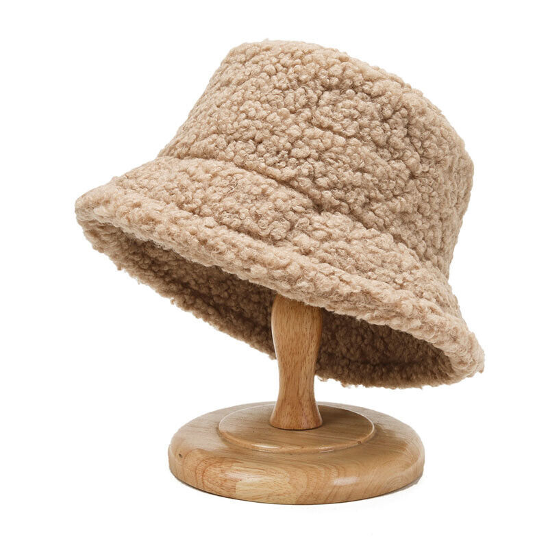 Beiger Teddyfell-Bucket-Hut auf Holzständer, modisch, warm, Winteraccessoire.