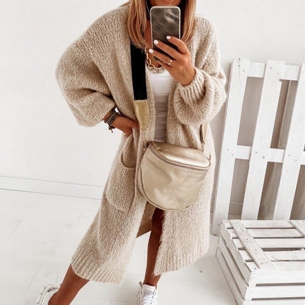Frau in beiger Strickjacke, lässig, modisch, bequem, mit Tasche, Herbstmode für Damen.