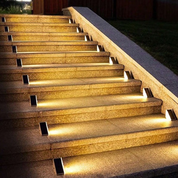 Beleuchtete Steintreppe im Freien, moderne LED-Stufenbeleuchtung, Nachtaufnahme