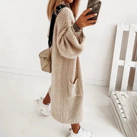 Frau in beiger Strickjacke, lässig, modisch, mit Tasche, weiße Sneaker, Herbstmode.