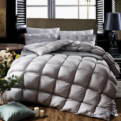 Luxuriöse graue Steppbettdecke auf Bett mit Kissen, ideal für gemütliches Schlafzimmerambiente.