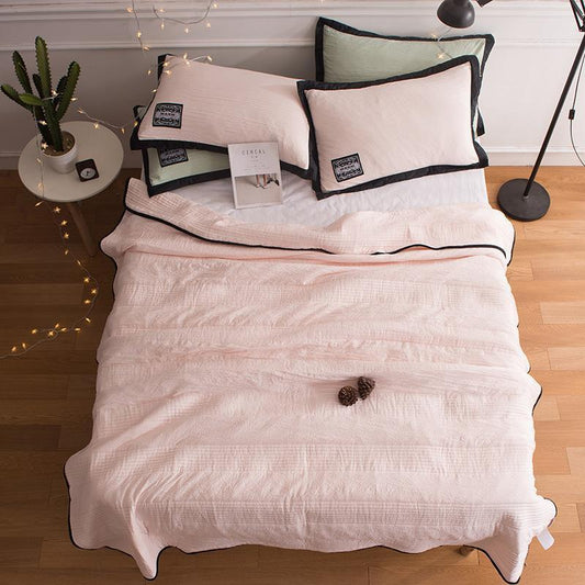 Bett mit rosa Bettdecke, Kissen, Buch und Lichterkette, skandinavisches Schlafzimmerdekor.