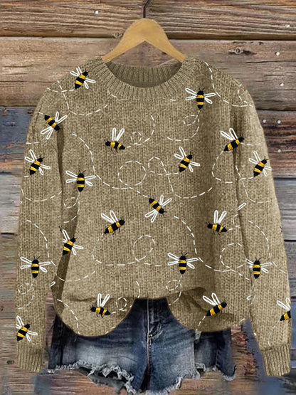 Bienen-Pullover aus Strick, beige, Damenmode, lässig, Herbst, Holz-Hintergrund.
