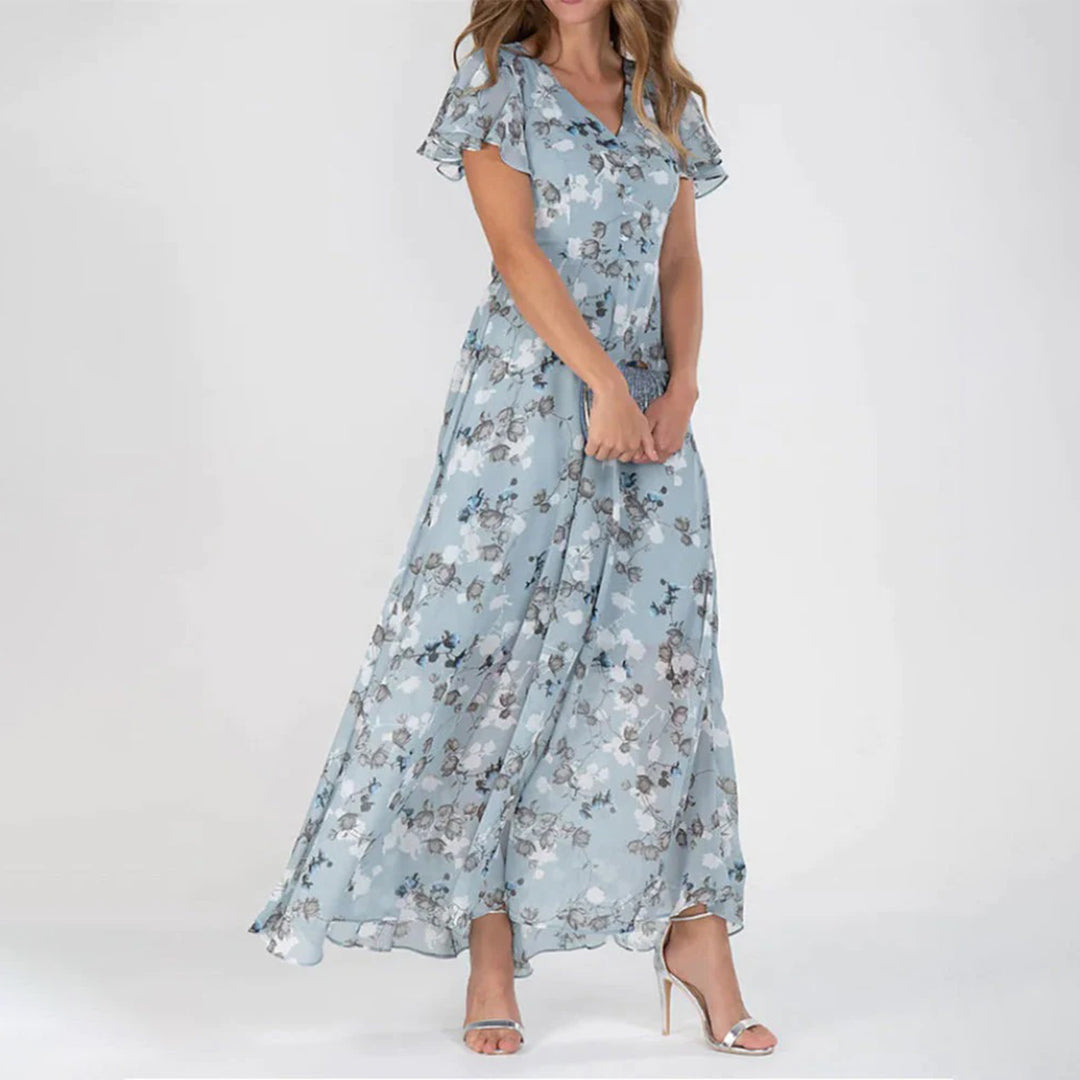 Frau in blauer, geblümter Maxikleid aus Chiffon, elegant, sommerlich, modisch.