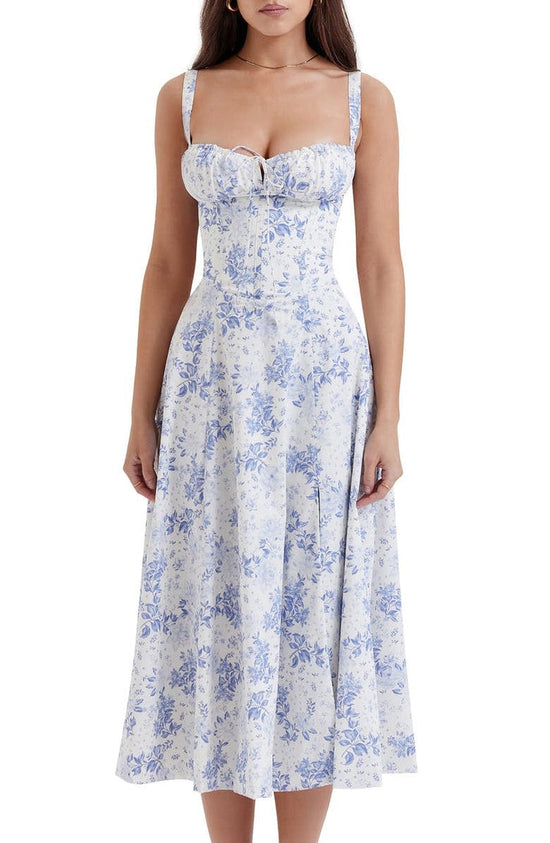 Frau in weiß-blauem floralen Bustier-Sommerkleid, ärmellos, knielang, elegantes Design.