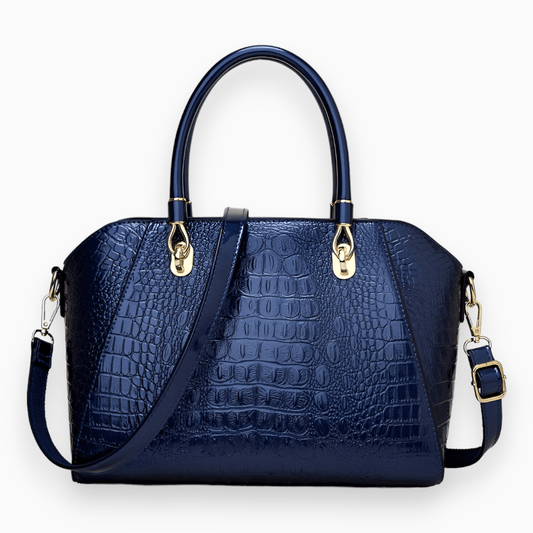 Dunkelblaue Krokodilleder-Handtasche mit goldenen Beschlägen und abnehmbarem Schulterriemen.