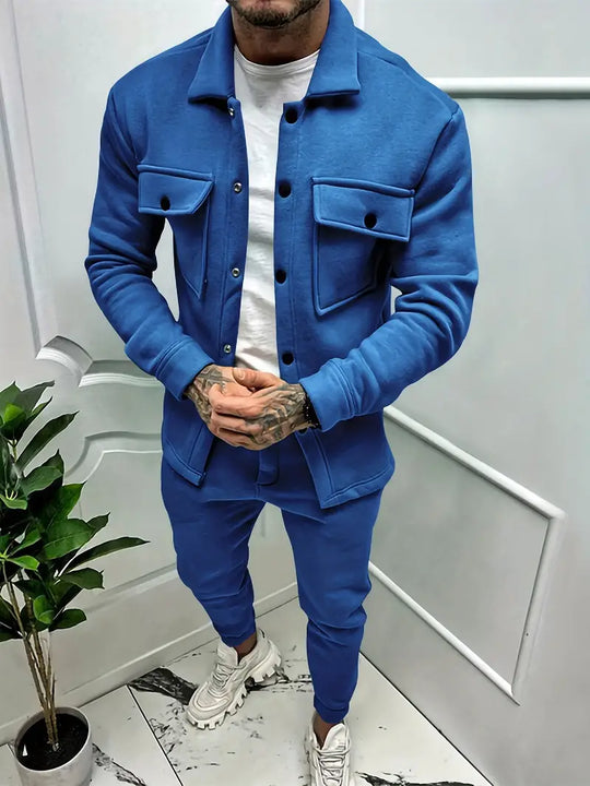 Mann in blauer Trainingsanzugjacke und Hose, weiße Sneakers, moderne Herrenmode.