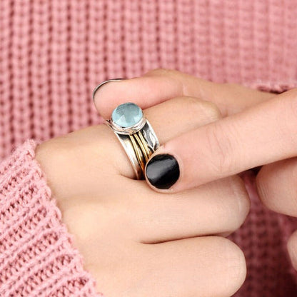 Silberring mit blauem Edelstein, Damenmode, eleganter Schmuck, gestrickter rosa Pullover.
