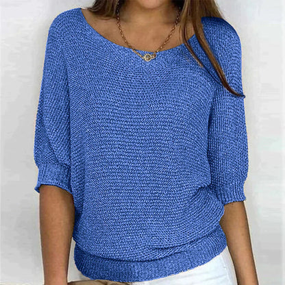 Frau trägt blauen Strickpullover, lässiger Stil, Dreiviertelärmel, modisch, bequem.