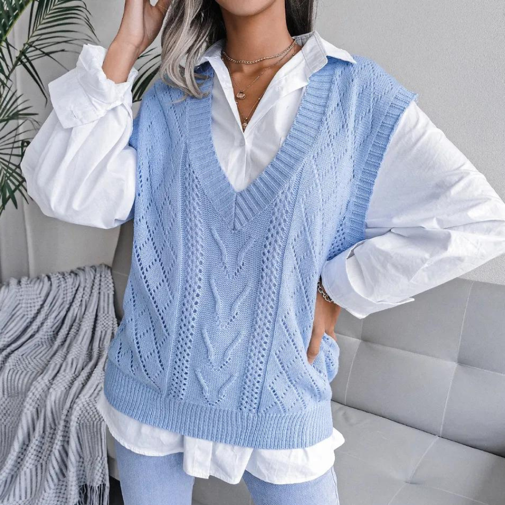 Frau in blauem Strickpullunder über weißer Bluse, modisch, lässig, Wohnzimmer.