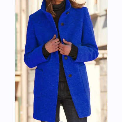 Frau in blauem Wollmantel, schwarze Jeans, Herbstmode, stilvoll, urbaner Hintergrund.