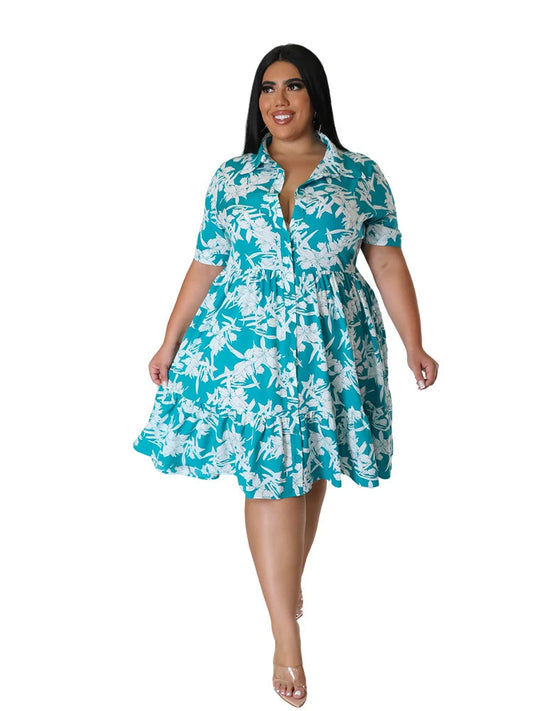 Frau im türkis-weißem Blumenkleid, Plus-Size, Sommermode, knielang, kurzärmelig.