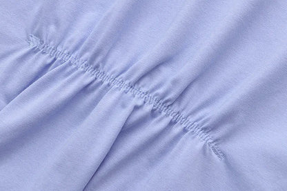 Hellblauer Baumwollstoff mit elastischer Raffung, Nahaufnahme, Textilstruktur, Mode.
