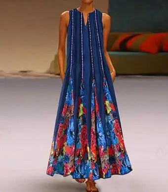 Frau in blauem Maxikleid mit buntem Blumenmuster, ärmellos, elegantes Sommeroutfit.