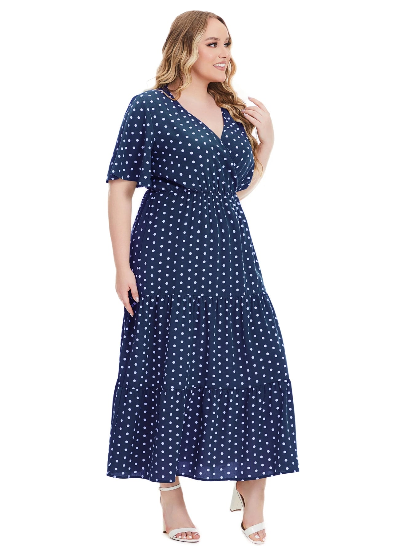 Frau im blauen Maxikleid mit weißen Punkten, V-Ausschnitt, Plus-Size, Sommermode.