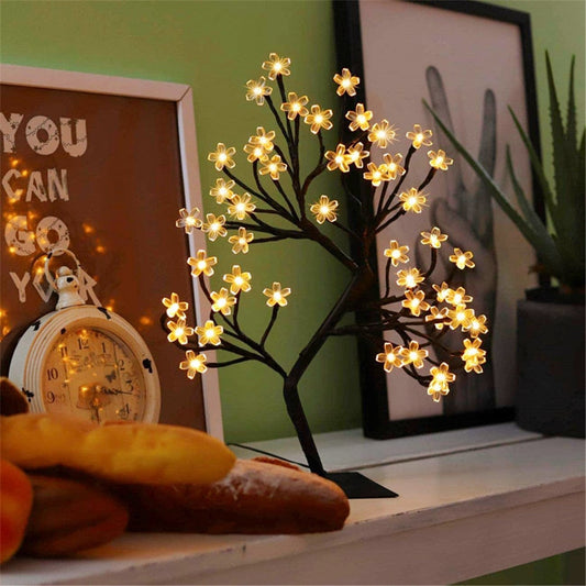 LED-Baumlampe mit leuchtenden Blüten, dekorativ, warmweiß, auf Regal, moderne Inneneinrichtung.