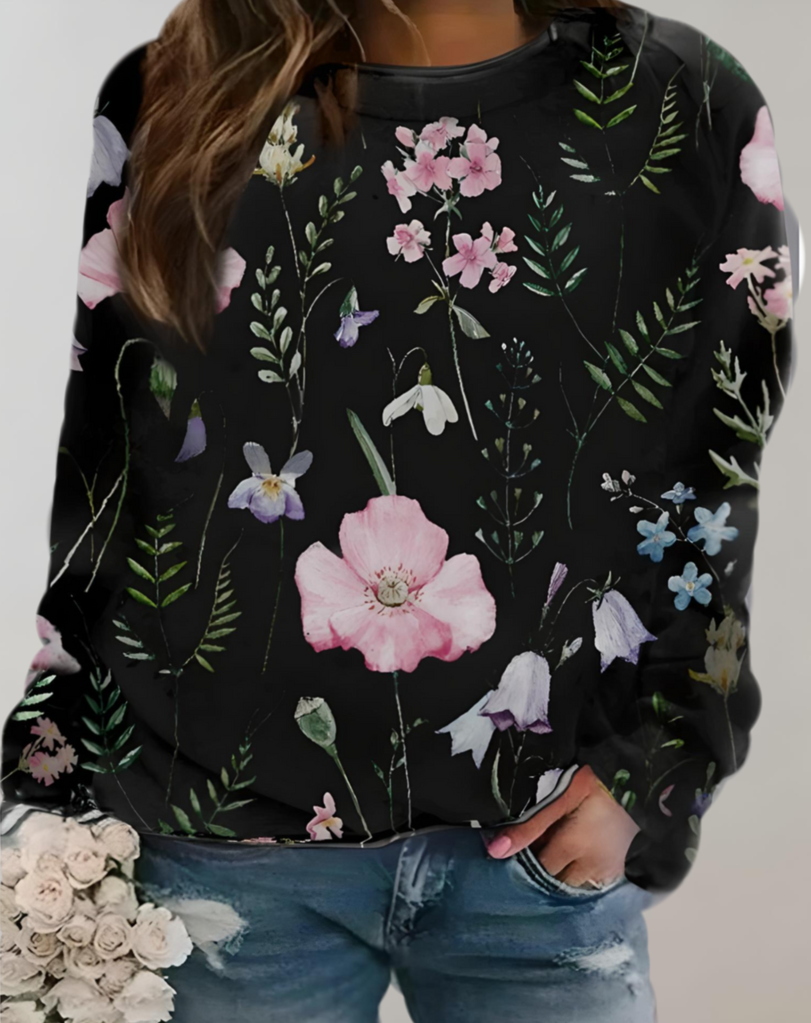 Frau in schwarzem Blumenpullover, lässige Jeans, Blumenmuster, modisch, Freizeitkleidung.