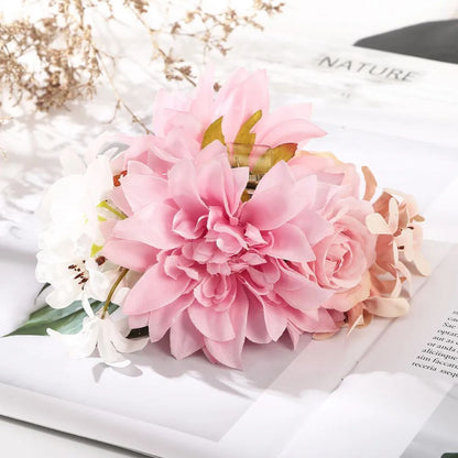 Rosa und weiße künstliche Blumen auf Zeitschrift, dekorative Tischdekoration.